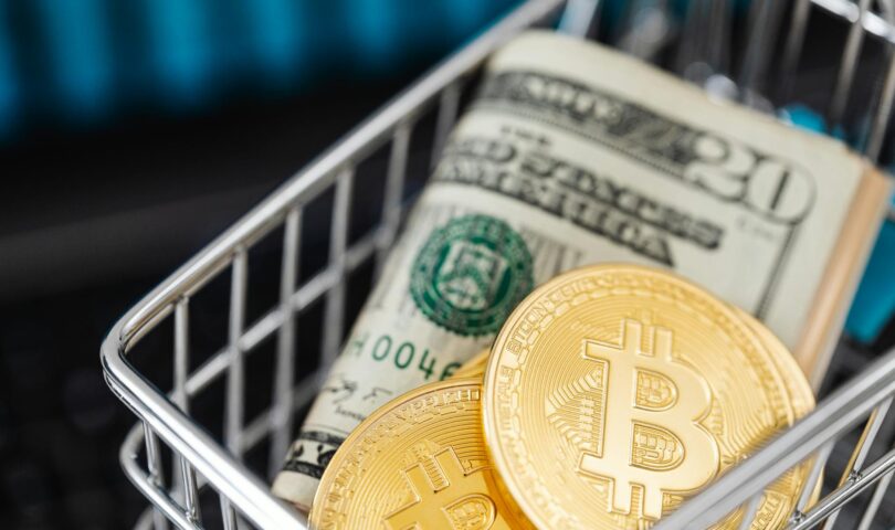 paper bills and coins inside a miniature shopping cart